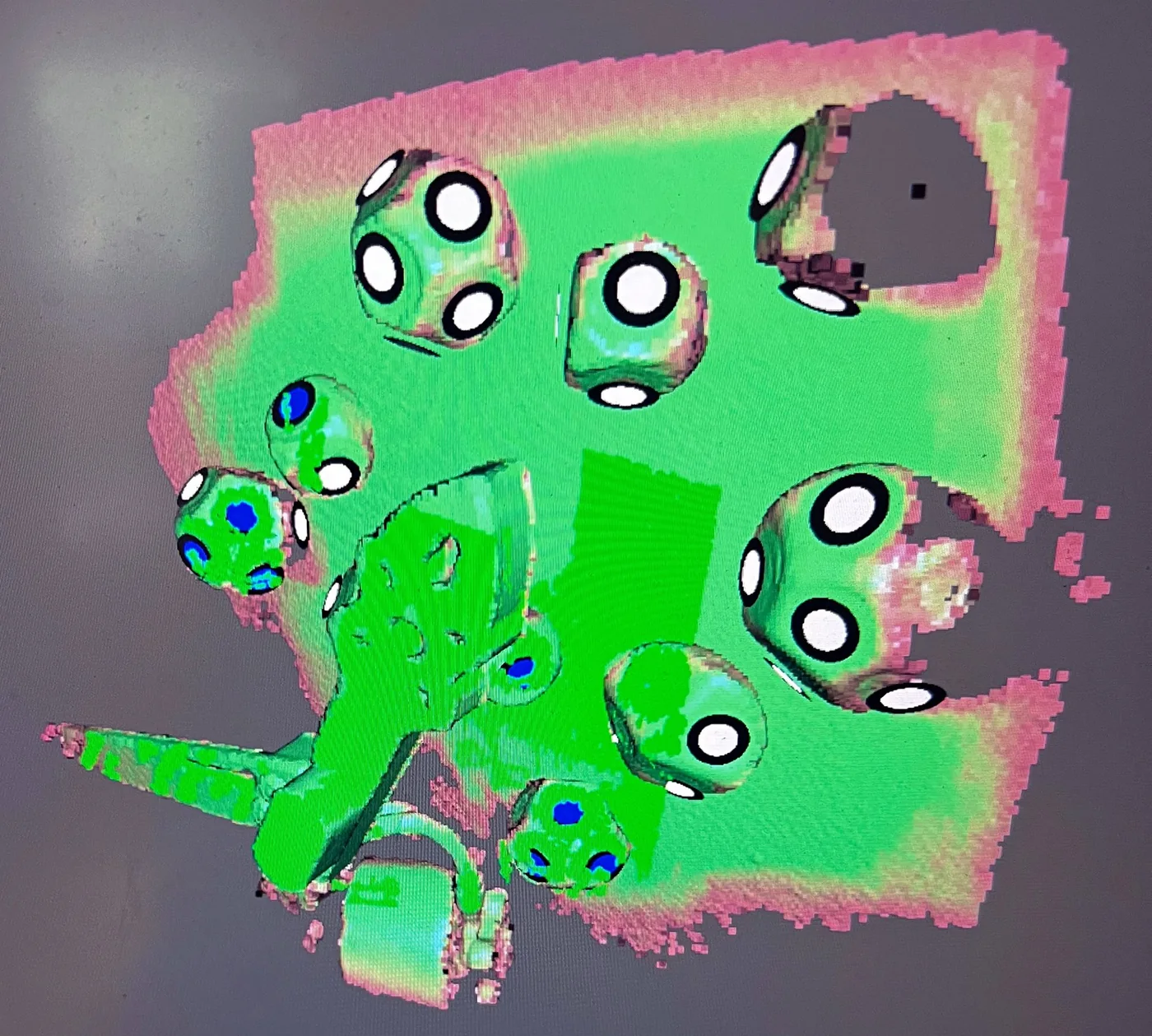 La scansione 3D di un braccio di drone con i marker a pallini, colorata dal programma di scansione.